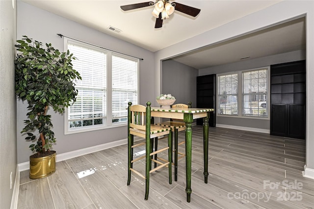 dining room with light wood-style floors, baseboards, visible vents, and ceiling fan