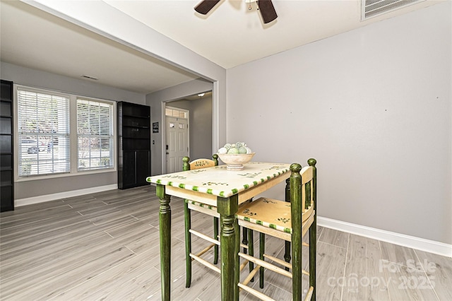 dining area featuring visible vents, light wood-style flooring, and baseboards