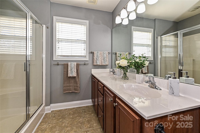 bathroom featuring double vanity, a stall shower, visible vents, and a sink