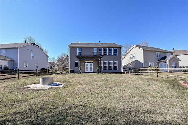 rear view of house with a fenced backyard, central AC unit, a lawn, and french doors