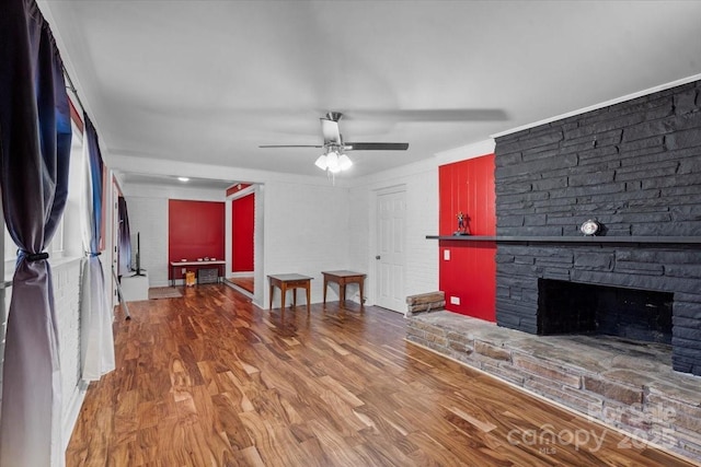 living room featuring a stone fireplace, ceiling fan, and hardwood / wood-style flooring