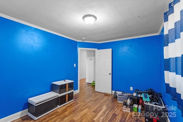 interior space featuring ornamental molding, hardwood / wood-style floors, and a textured ceiling