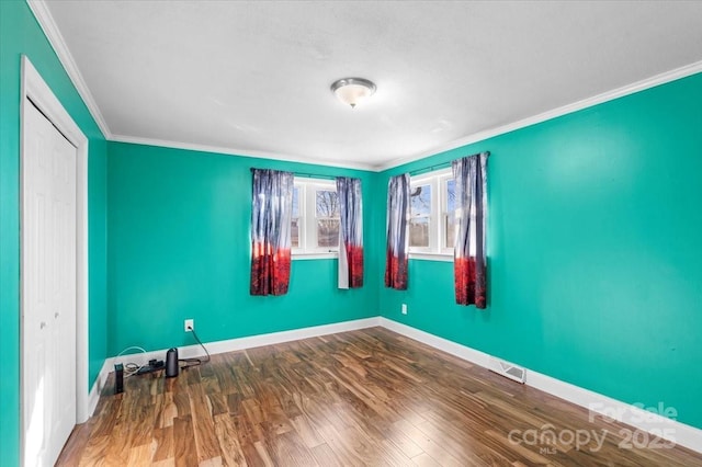 spare room with crown molding and wood-type flooring