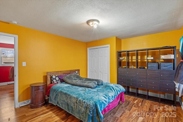 bedroom featuring hardwood / wood-style floors, a textured ceiling, and a closet