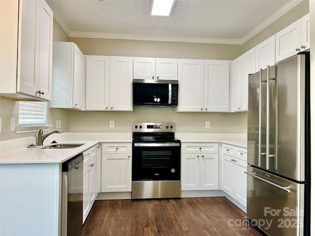 kitchen with crown molding, stainless steel appliances, dark wood finished floors, white cabinetry, and a sink