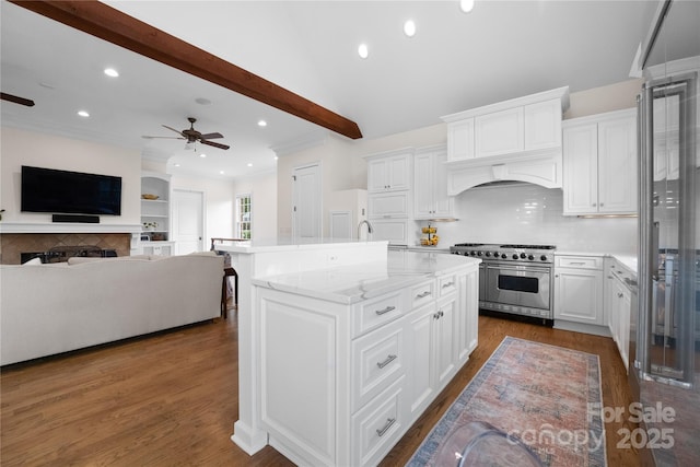 kitchen with double oven range, a kitchen island with sink, white cabinetry, and dark wood-style flooring