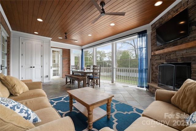 living area featuring wooden ceiling, ceiling fan, a fireplace, and recessed lighting