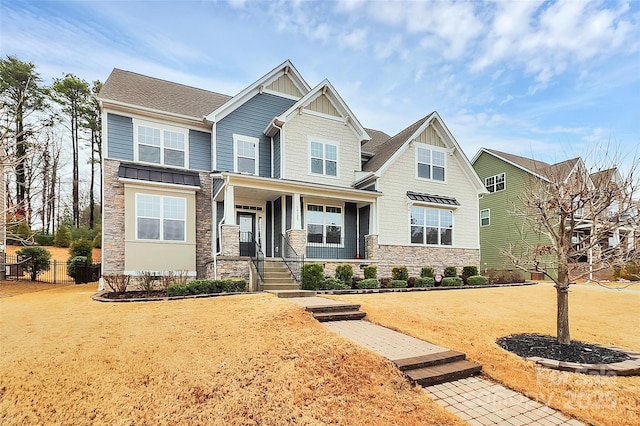 craftsman-style house featuring covered porch and a front lawn