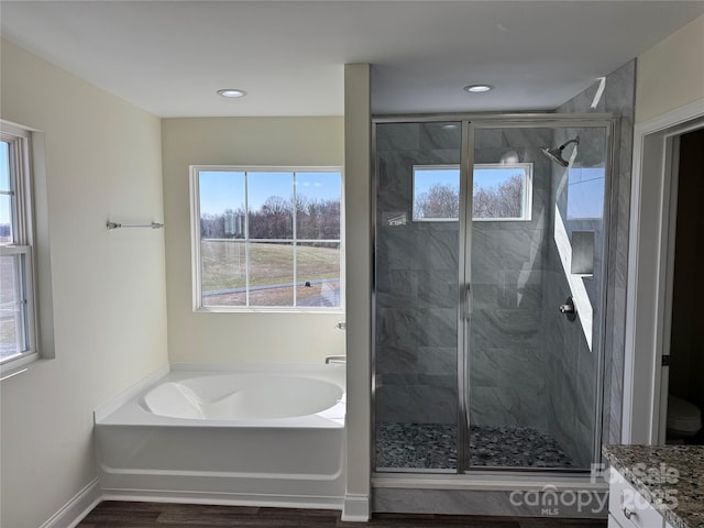 bathroom with vanity, hardwood / wood-style floors, and separate shower and tub