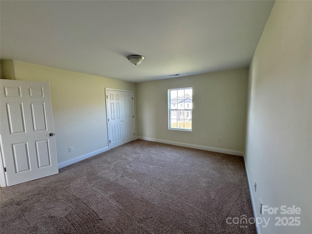 unfurnished bedroom featuring carpet and a closet