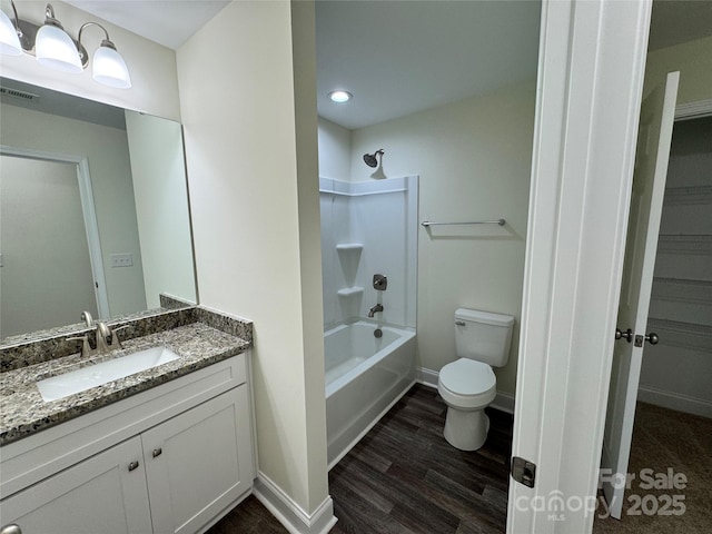 full bathroom featuring vanity, hardwood / wood-style flooring, toilet, and washtub / shower combination