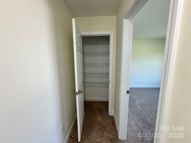 corridor featuring dark colored carpet