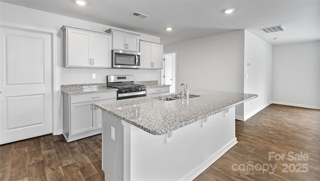 kitchen featuring a kitchen island with sink, sink, a breakfast bar area, and stainless steel appliances