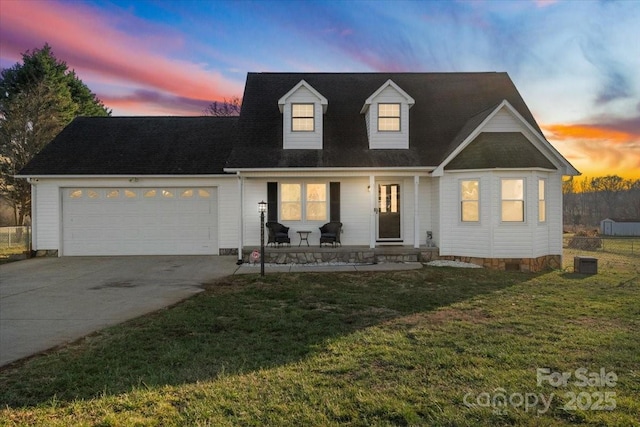 cape cod home with a porch, a garage, and a yard