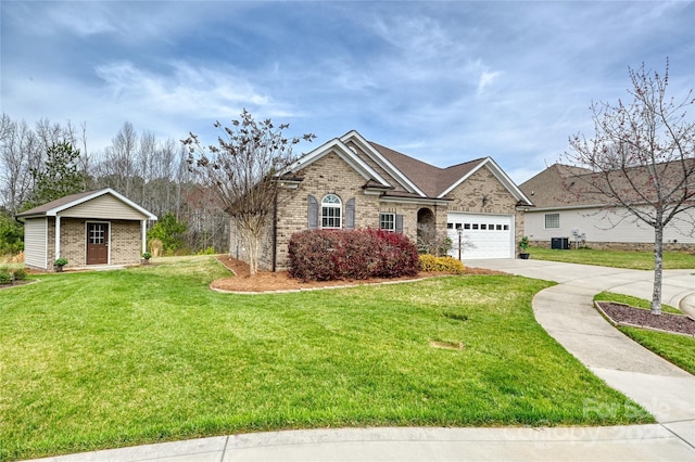 ranch-style house featuring an outbuilding, a front lawn, concrete driveway, a garage, and brick siding