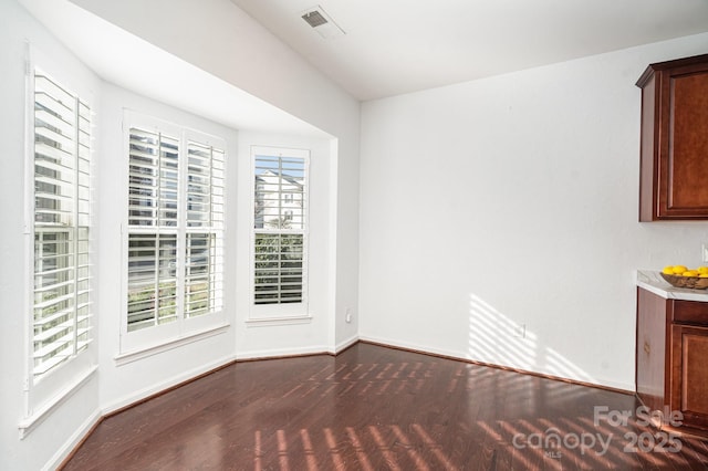 unfurnished dining area featuring dark hardwood / wood-style floors