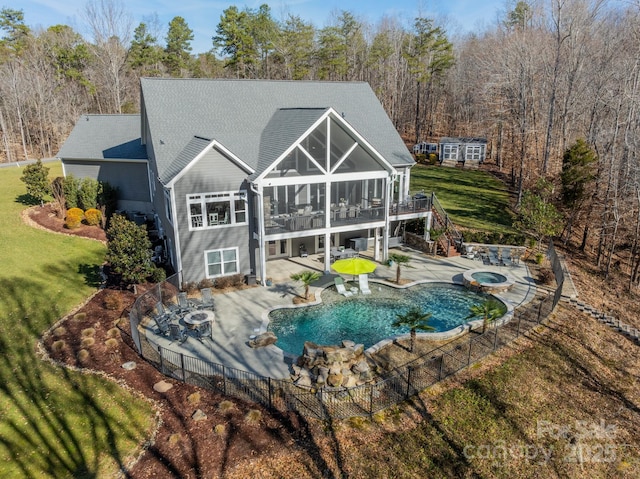 view of pool featuring a lawn, a deck, a patio, a sunroom, and an in ground hot tub