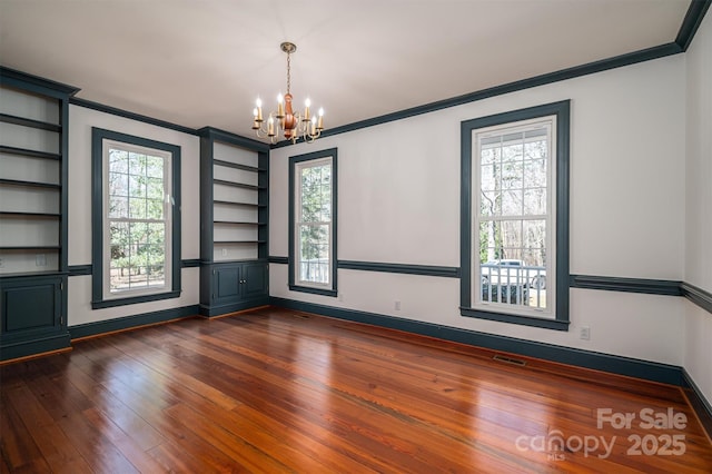 empty room featuring dark wood-style floors, ornamental molding, and visible vents