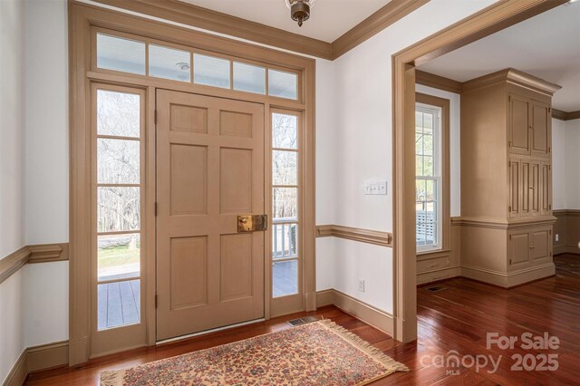 entryway featuring baseboards, visible vents, dark wood-style flooring, and crown molding