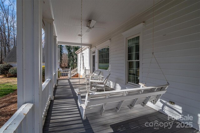 wooden terrace with covered porch and a ceiling fan