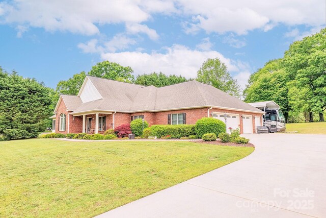 119 Era St, Troutman, NC 28166 - view of front facade featuring brick siding, an attached garage, a front lawn, concrete driveway, and a shingled roof