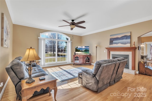 119 Era St, Troutman, NC 28166 - living area with ceiling fan, wood finished floors, crown molding, a tile fireplace, and arched walkways