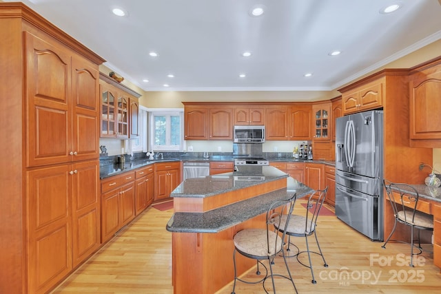 119 Era St, Troutman, NC 28166 - kitchen with stainless steel appliances, crown molding, brown cabinetry, light wood-style flooring, and a breakfast bar