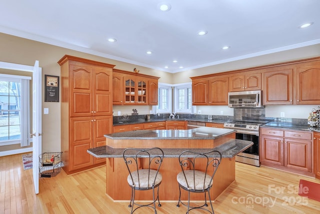 119 Era St, Troutman, NC 28166 - kitchen with appliances with stainless steel finishes, a center island, a sink, a kitchen breakfast bar, and light wood-type flooring