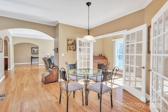 119 Era St, Troutman, NC 28166 - dining room featuring light wood-style floors, arched walkways, crown molding, french doors, and baseboards