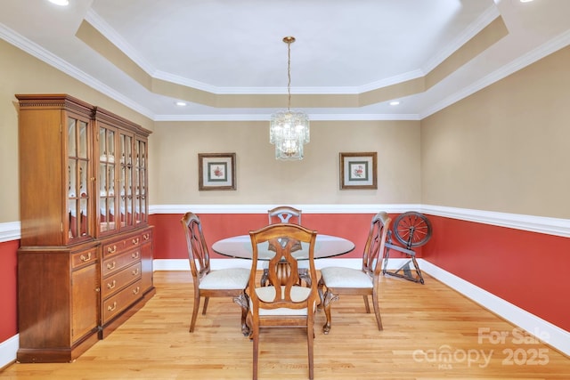 119 Era St, Troutman, NC 28166 - dining space with light wood-style flooring, a raised ceiling, baseboards, a chandelier, and ornamental molding
