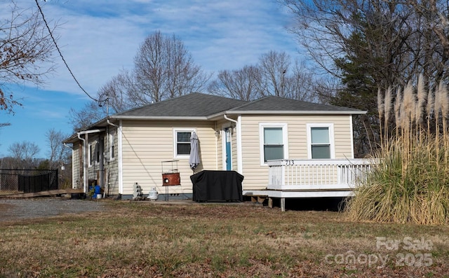 view of front of property with a deck and a front lawn