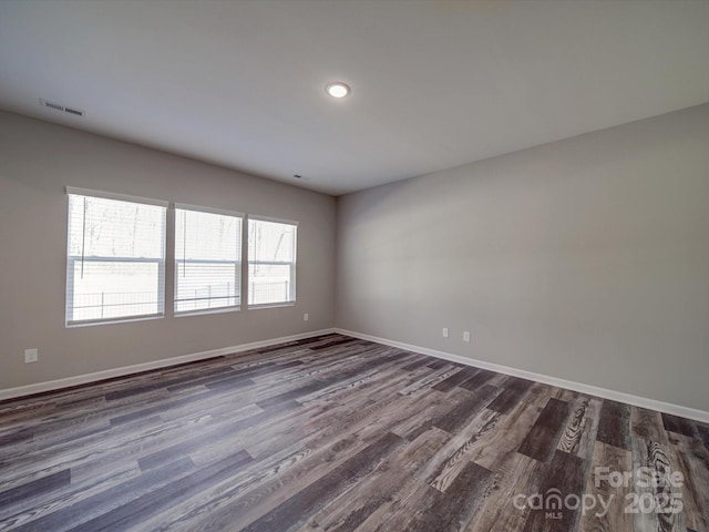 empty room with dark hardwood / wood-style flooring