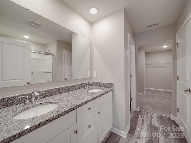 bathroom with vanity, an enclosed shower, and wood-type flooring