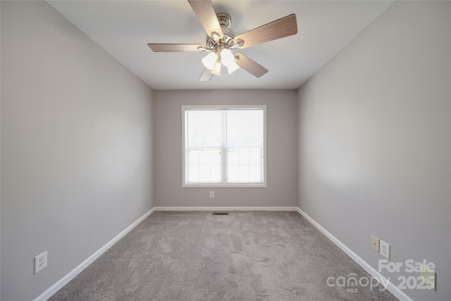 empty room featuring light carpet, ceiling fan, visible vents, and baseboards