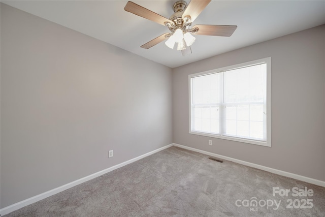 unfurnished room with visible vents, baseboards, a ceiling fan, and light colored carpet