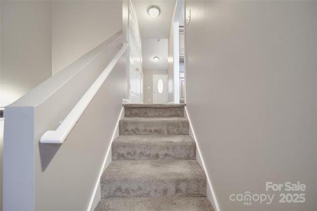 stairs featuring carpet and baseboards