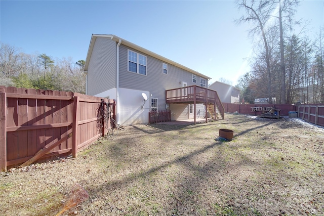 rear view of house featuring a deck, a lawn, a fenced backyard, and stairs