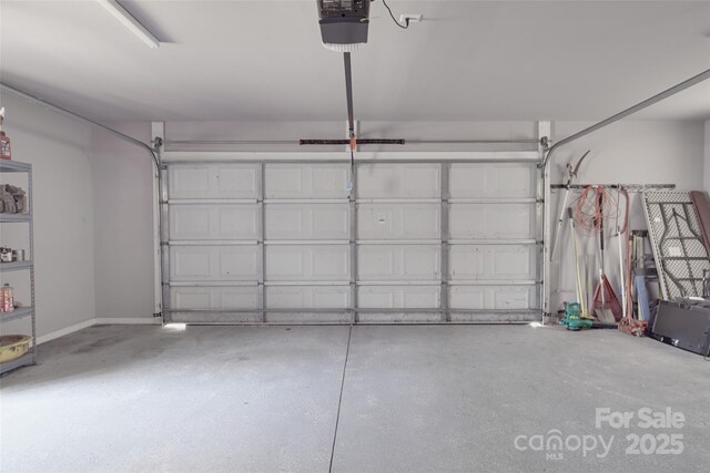 garage with baseboards and a garage door opener