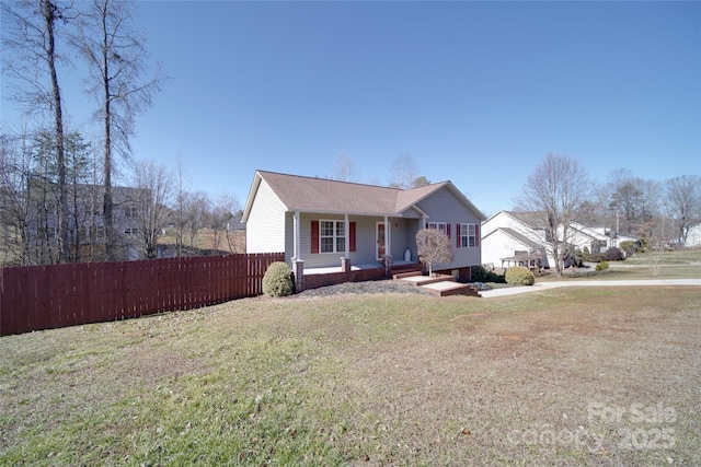 view of front of property featuring covered porch, a front yard, and fence