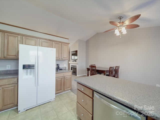 kitchen with white refrigerator with ice dispenser, light countertops, light brown cabinets, vaulted ceiling, and dishwasher