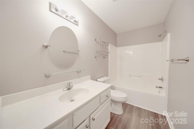 bathroom with washtub / shower combination, vanity, toilet, and wood finished floors