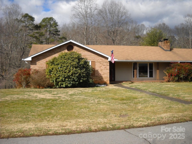 single story home with a front lawn, a chimney, and brick siding