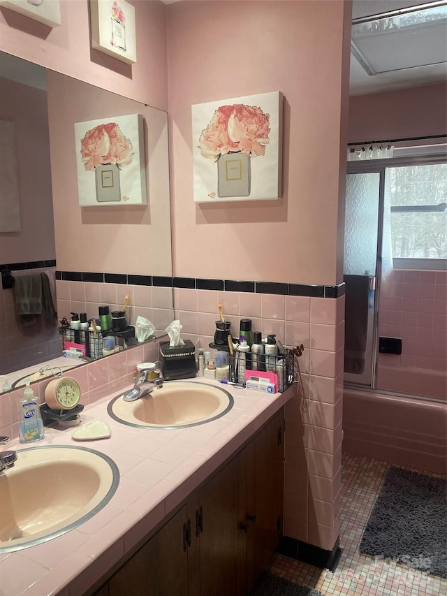 full bathroom featuring double vanity, tile patterned flooring, tile walls, and a sink