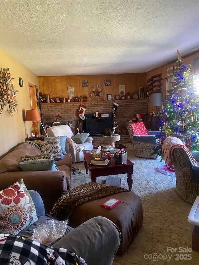 living room with a textured ceiling, carpet floors, and a fireplace