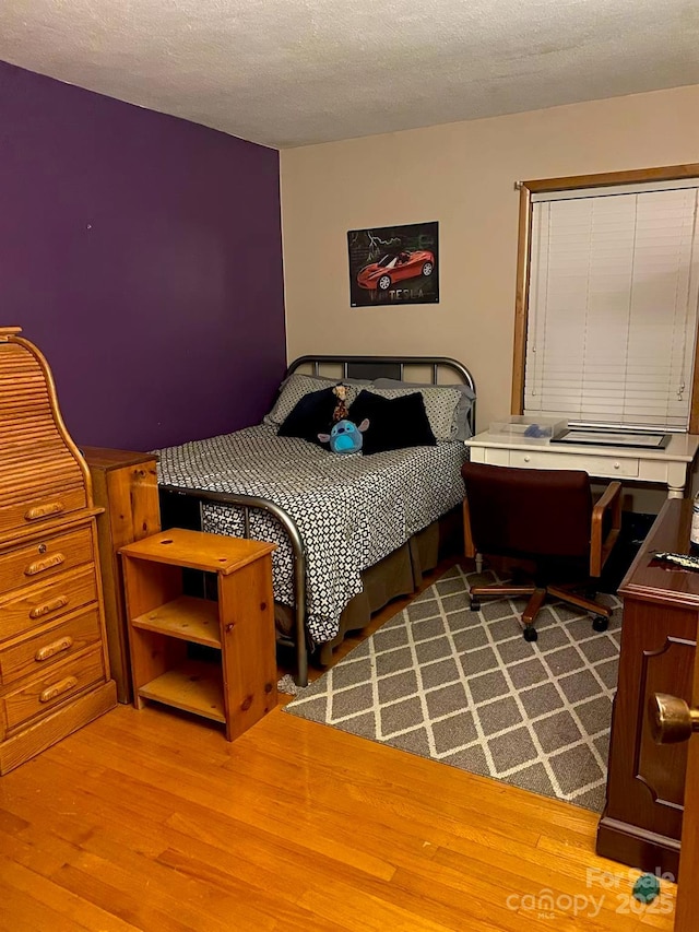 bedroom featuring a textured ceiling and wood finished floors