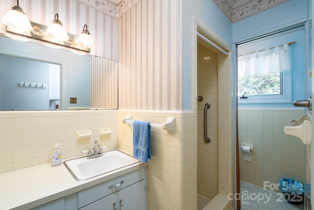 bathroom with tile walls, vanity, and tiled shower