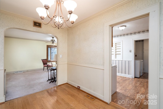 corridor with crown molding, wood-type flooring, and washer / dryer