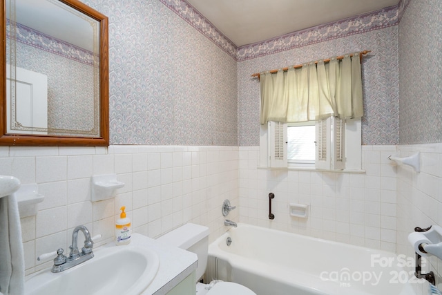 bathroom featuring tile walls, a tub, vanity, and toilet