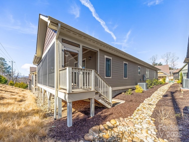 view of side of home featuring a sunroom and central air condition unit