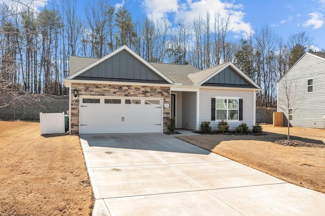 view of front of house with a shingled roof, an attached garage, board and batten siding, stone siding, and driveway